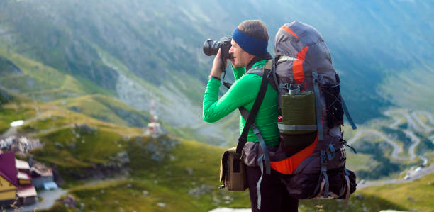 istock man with backpack on the mountain. photographer taking photos 1170172825