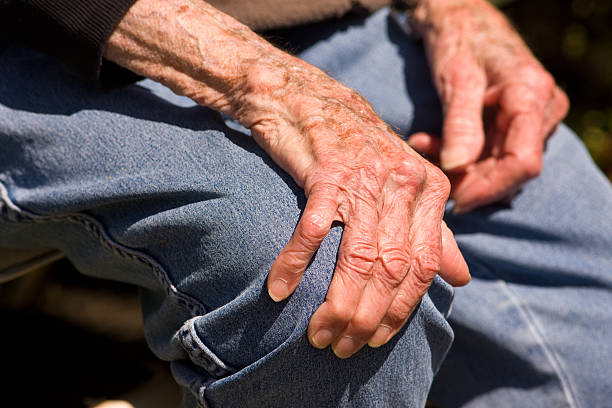 istock A pair of elderly hands grasping a denim clad knee 117017379