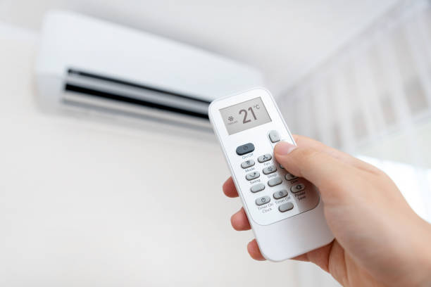 istock Hand with remote directed on air conditioner. 1170174696