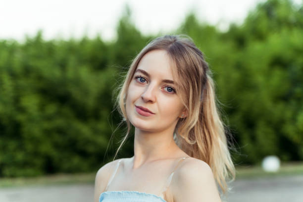 Beautiful smile of young girl standing in front of the forest
