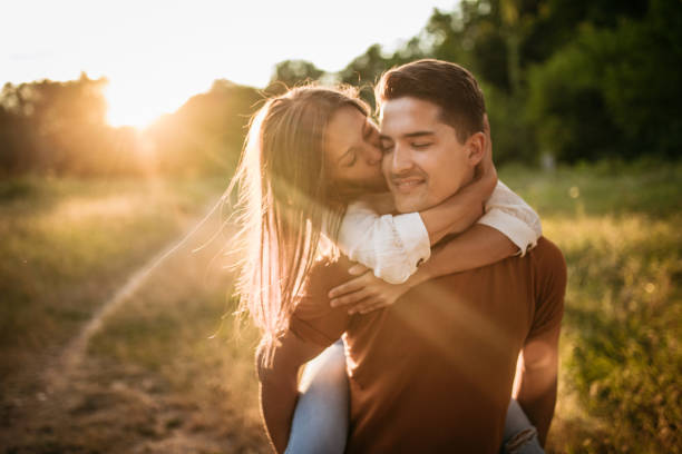 istock Young guy piggybacking cheerful girlfriend next to the river 1170180223