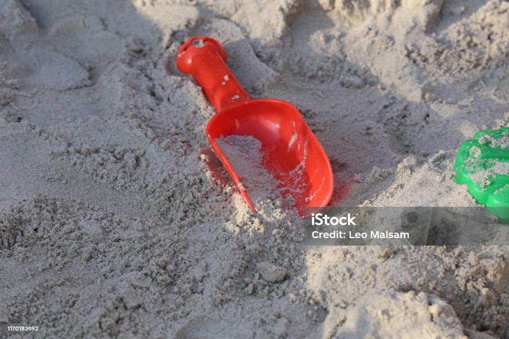 Helle Kinderspielzeuge liegen im Sandkasten - Lizenzfrei Blau Stock-Foto