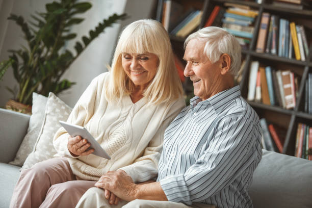 istock Senior couple together at home retirement concept using digital tablet looking at screen 1170192554