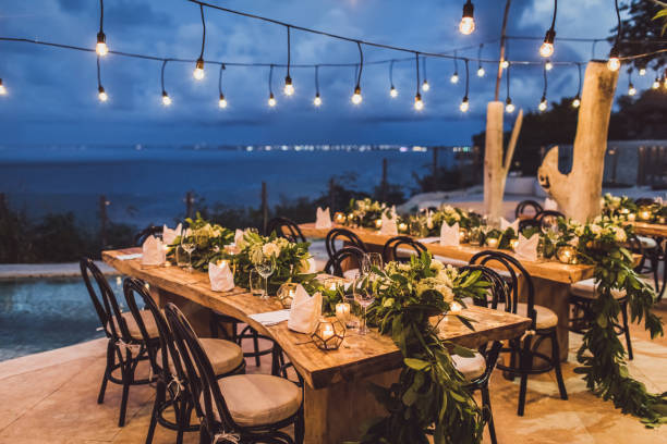 istock Table setting at night wedding ceremony. Decoration with fresh flowers, candles, light bulbs, garlands. VIntage style. 1170192599