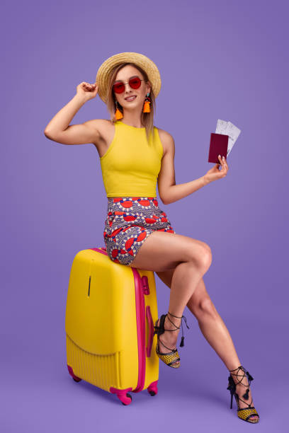 istock Female traveler with tickets sitting on suitcase 1170192888
