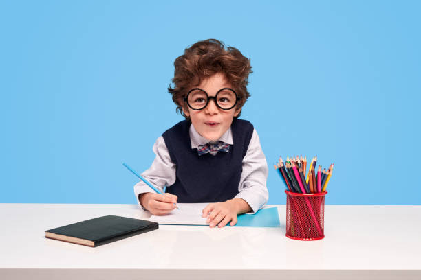 zabawny uczeń robi pracę domową - child writing education nerd zdjęcia i obrazy z banku zdjęć