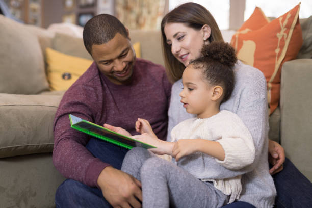istock Mixed race family reading a book together 1170196138