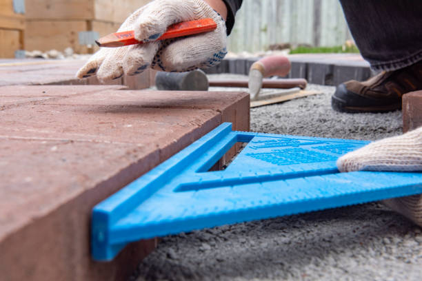 instalacja cegieł brukarzy na patio na podwórku. ręce robotnika w rękawiczce używają młotka do umieszczenia kamiennych brukarzy. - concrete driveway cement construction zdjęcia i obrazy z banku zdjęć