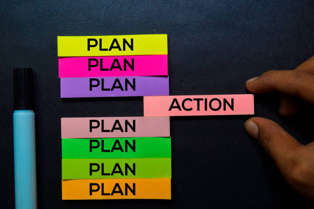 Plan or Action text on sticky notes isolated on Black desk. Mechanism Strategy Concept stock photo
