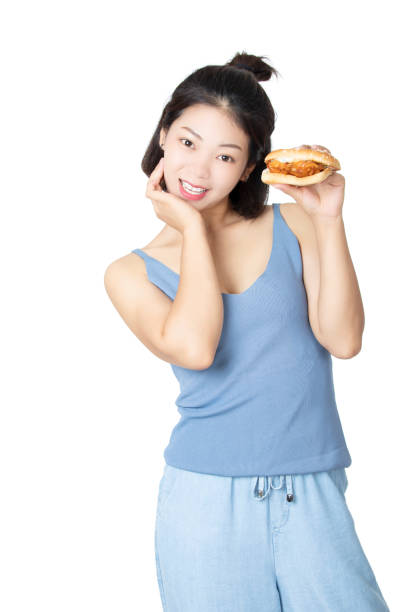 Chinese American woman eating Chicken Sandwich isolated on white background