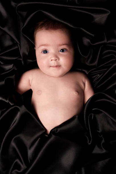 Little baby girl lying on her back, looking away happily