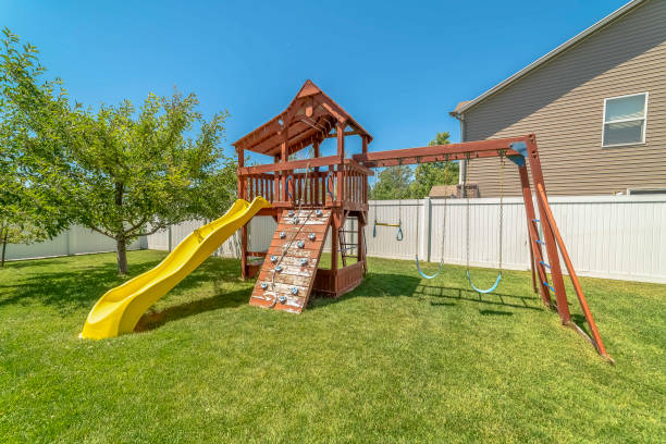 istock Wooden playground structure with yellow plastic slide swings and climbing wall 1170228893