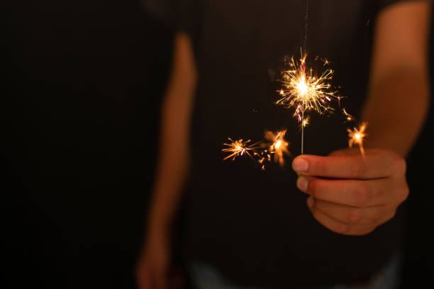 junges mädchen brennt funkeln in der hand - sparkler sparks new years eve human hand stock-fotos und bilder