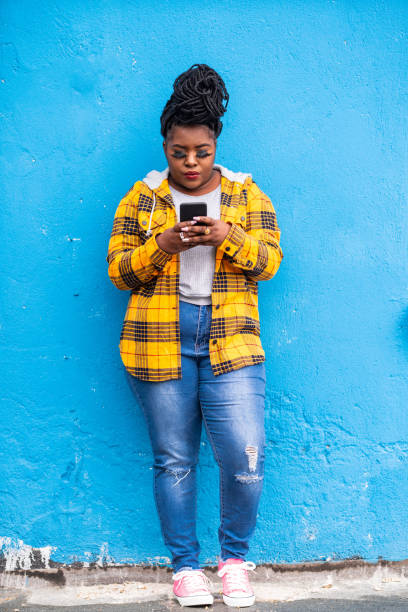 istock Afro woman using smart phone on a blue background 1170230041