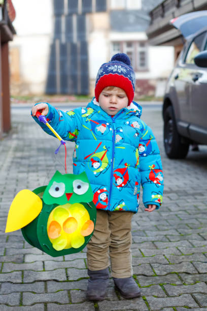 istock Little kid boy holding selfmade lanterns for a Halloween or St. Martin procession. Beautiful healthy cute child happy about children and family parade in kindergarten. German tradition Martinsumzug 1170236204