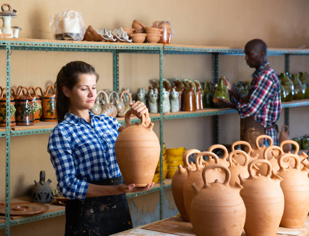 istock Female arranging clay goods on shelves 1170241346