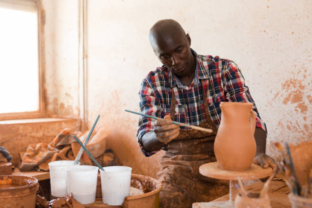 istock Potter painting ceramic pot 1170241432