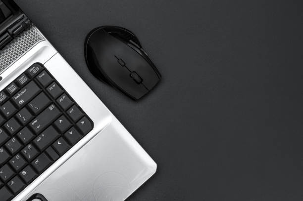 istock Computer mouse and laptop on black background. Top view. Space for text. 1170244697