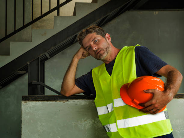 istock problem at the building site. Attractive stressed and frustrated construction worker man in vest and builder helmet looking tired and worried suffering problem in blue collar job lifestyle concept 1170247199