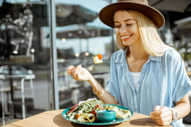 istock Woman eating salad on a cafe terrace 1170247589