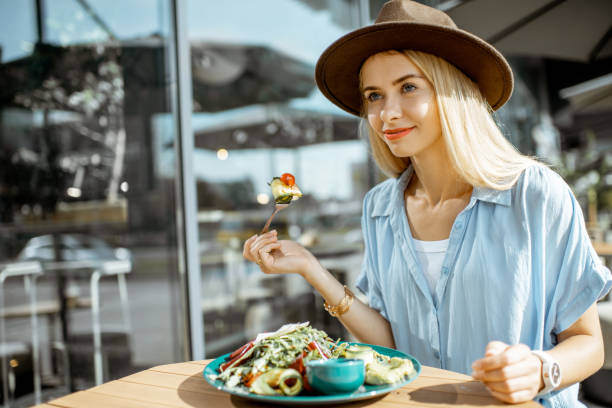 istock Woman eating salad on a cafe terrace 1170247595