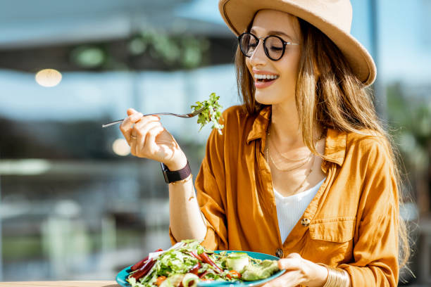 istock Woman eating salad on a cafe terrace 1170247614