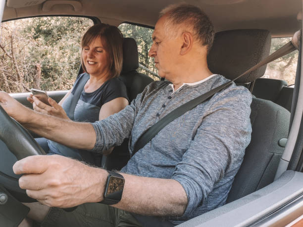 istock Senior couple driving in car using phone as navigation 1170248672