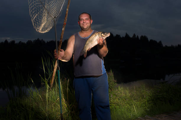 A man holds a fish on the lake.
