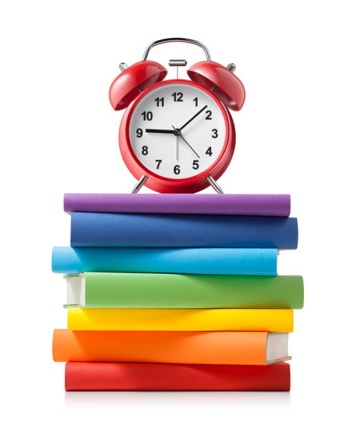 istock Alarm clock on stack of colored books on white background 1170253615