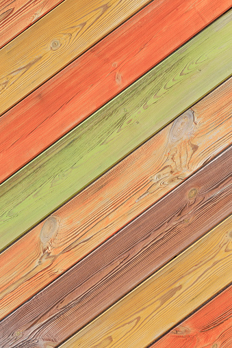 Abstract multicolored colorful vertical diagonal striped background in beautiful pastel autumn colors with the surface texture of wooden boards painted in yellow orange green brown colors