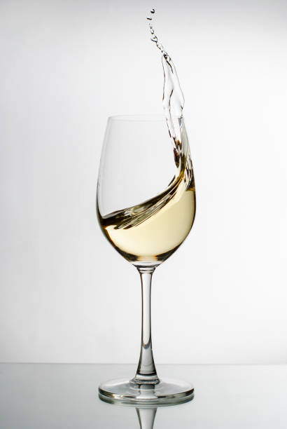 istock White wine splashing from an elegant wineglass 1170256277