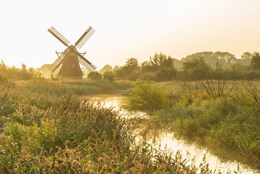 Traditional Dutch windmill in a nature area on a summers morning. Groningen, Holland.