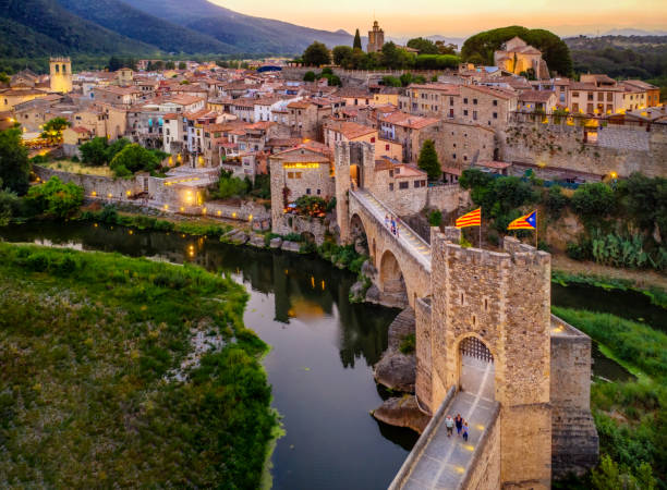 aerial view of the Medieval bridge of the Besalu at dusk. Catalonia, Spain aerial view of the Medieval bridge of the Besalu at sunset. Catalonia, Spain drawbridge photos stock pictures, royalty-free photos & images