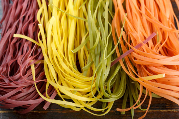 istock multi-colored long spaghetti. traditional italian pasta on a wooden background. 1170259162