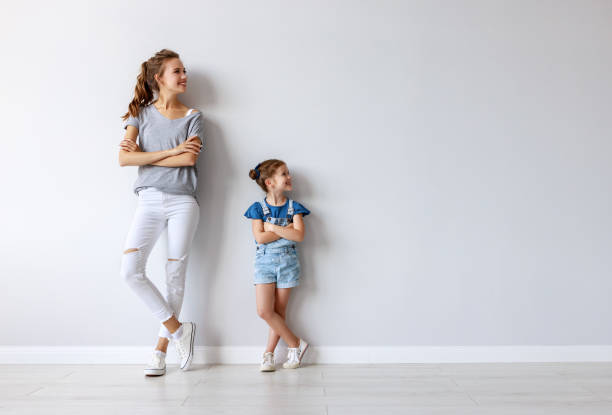 happy family mother (big sister) and child daughter near an empty wall happy family mother (big sister) and child daughter near an empty brick wall mom and sister stock pictures, royalty-free photos & images