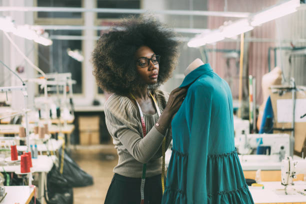 Young fashion designer Young fashion designer at her workplace woman tailor stock pictures, royalty-free photos & images
