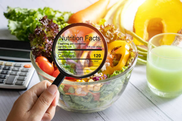 nutritional information concept. hand use the magnifying glass to zoom in to see the details of the nutrition facts from food , salad bowl nutritional information concept. hand use the magnifying glass to zoom in to see the details of the nutrition facts from food , salad bowl nutrition label stock pictures, royalty-free photos & images