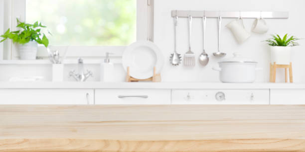 istock Wooden table top on blur kitchen room and window background 1170265024