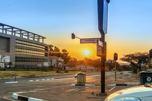 Sandton city with Grayston and Sandton drive intersection at sunset.\nSandton houses approximately 300 000 residents and 10 000 businesses, including investment banks, top businesses, financial consultants, the Johannesburg stock exchange and one of the biggest convention centres on the African continent, the Sandton Convention Centre.