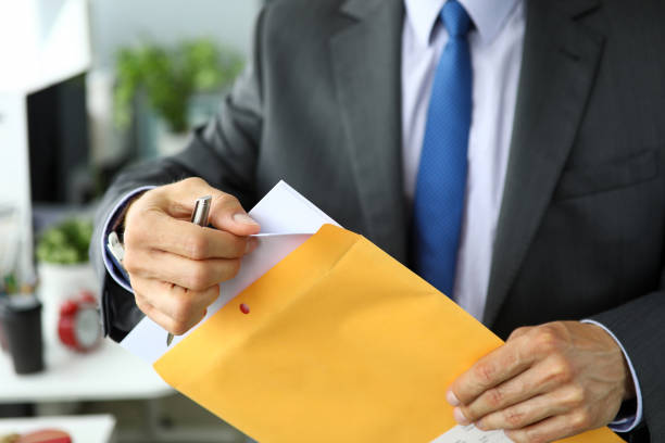istock Clerk in suit and tie at workplace packing envelope unpacking envelope with important documentation 1170267174