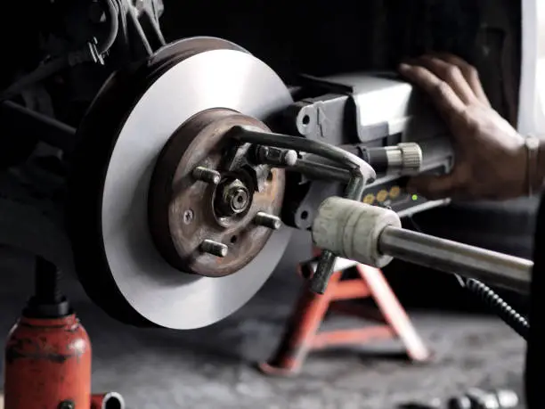 Grinding machine and vehicle brake-disc in garage.
