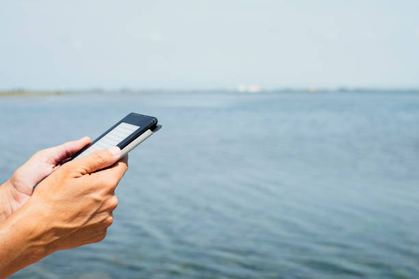 leitura do homem em um tablet ou e-reader - reading beach e reader men - fotografias e filmes do acervo