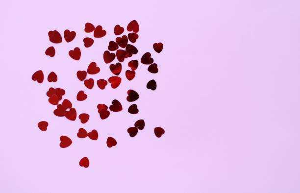 istock Hearts confetti shiny red on pink background 1170269862