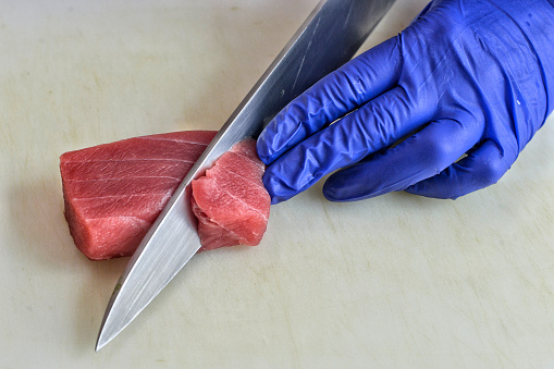 Close-up of the hands of a chef making sushi.