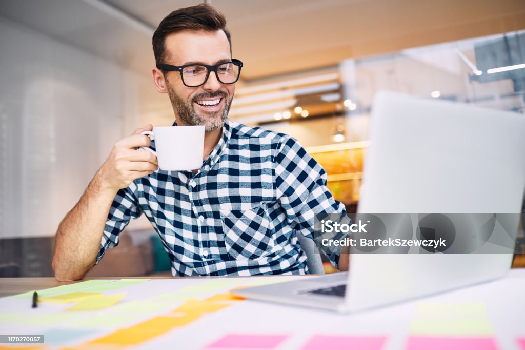 Glücklicher Geschäftsmann trinken Kaffee arbeiten auf seinem Laptop von zu Hause büro - Lizenzfrei Kaffee - Getränk Stock-Foto