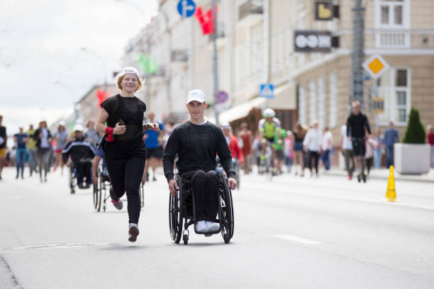 les personnes handicapées et en bonne santé courent ensemble un marathon - golf athlete photos et images de collection