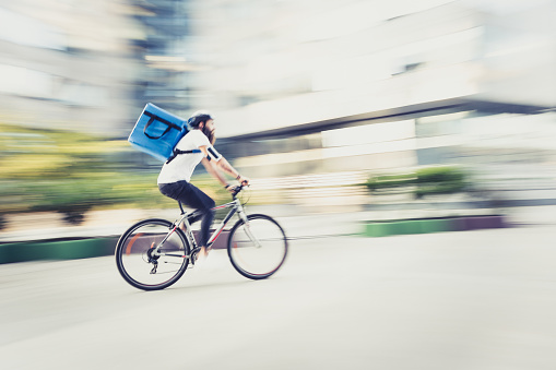 Food delivery on bicycle. Panning technique, blued motion
