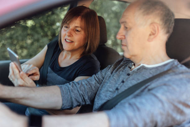 istock Senior couple driving in car and using phone as navigation 1170276347