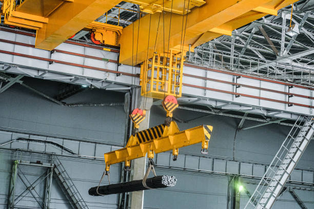 Yellow overhead crane carries cargo in engineering plant shop. Jib crab trolley with hooks and linear traverse. Yellow overhead crane carries cargo in engineering plant shop. Jib crab trolley with hooks and linear traverse. jib stock pictures, royalty-free photos & images