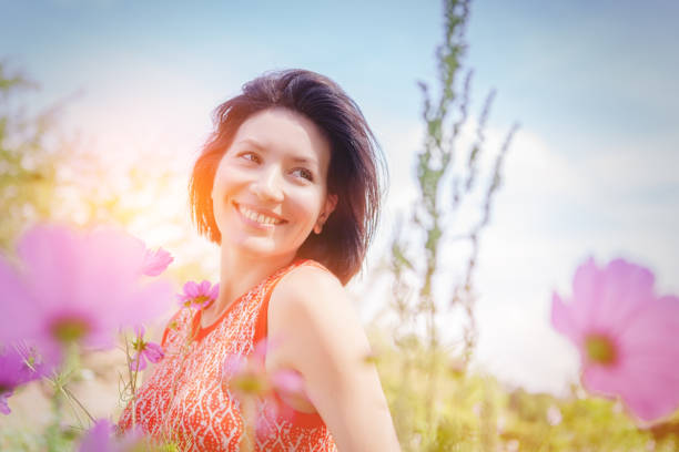 Lovely happy female closeup portrait, sitting in the poppy flower field